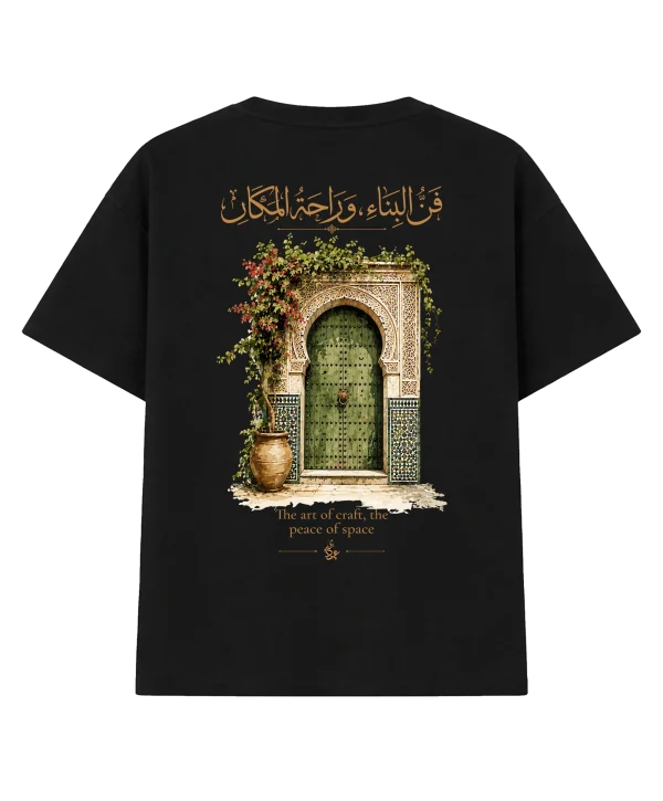 T-shirt oversize « Heritage » noir, vu de dos : grande illustration d’une porte verte à zellige entourée de fleurs, surmontée d’une calligraphie arabe