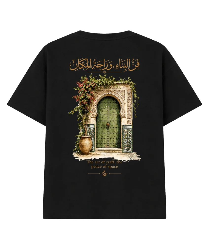 T-shirt oversize « Heritage » noir, vu de dos : grande illustration d’une porte verte à zellige entourée de fleurs, surmontée d’une calligraphie arabe